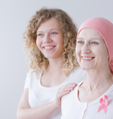 A patient wearing a chemo cap. She smiles.